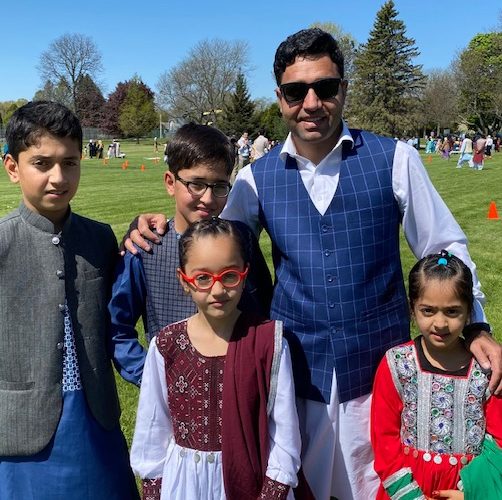 A man posing with his family at an Open Doors for Refugees picnic