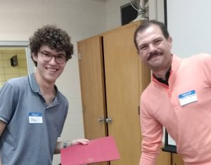 Faculty Director Steven Brooke presenting a graduating student with a certificate at the end of year party.